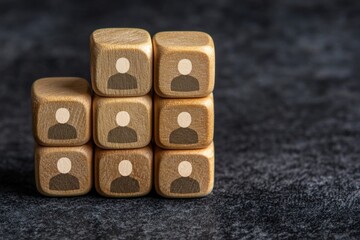 Poster - Wooden blocks with person icons, representing teamwork, collaboration, and community in a minimalist design on a dark surface.