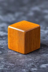 Poster - Close-up of a polished wooden cube on a textured surface, showcasing its rich grain and warm color in natural light.