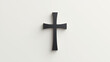 © Tameem - Simple black cross on a plain wall, embodying Christian symbolism.