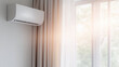 © Jirawatfoto - Wall mounted air conditioner installed near window with sunlight streaming through curtains, creating cozy and refreshing atmosphere