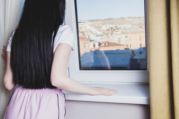 Wall Mural - girl looks through a window