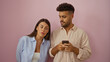 © Krakenimages.com - Woman spying on man using mobile phone with suspicious look on isolated pink background