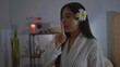 © Krakenimages.com - Beautiful asian woman making a silence gesture with her finger in a tranquil spa room adorned with soft lighting and wellness decor