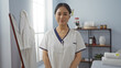 © Krakenimages.com - Beautiful young chinese woman smiling in a spa salon wellness center, standing indoors in a relaxing, serene, and professional indoor beauty room.