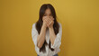 © Krakenimages.com - Young chinese woman over isolated yellow background covering mouth with hands showing shock or surprise