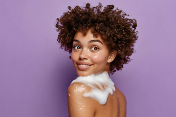 Wall Mural - A young female model with her back to the camera applies soap to one shoulder, with rich, foamy lather running down her skin