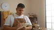 © Krakenimages.com - Young hispanic man in bakery writing notes in notebook indoors with pastries and breads visible in the background