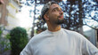 © Krakenimages.com - Handsome young arab muslim man with a beard standing outdoors in an urban park, looking confident and thoughtful