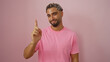 © Krakenimages.com - Young man with beard and styled hair pointing with his index finger while wearing a pink shirt, isolated over a pink background