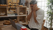 © Krakenimages.com - Young, arab man with beard in bakery looking stressed at laptop with pastries and red coffee cup visible