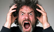 © hocine - Exaggerated Emotional Expression of a Man with Curly Hair Showing Frustration and Anger While Gripping His Head in Distress Against a Neutral Background
