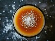 © TatChong - Top view of a salted caramel cocktail with coarse sea salt garnish