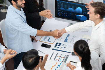 Wall Mural - Diverse group of office employee worker shake hand after making agreement on strategic business marketing meeting. Teamwork and positive attitude create productive and supportive workplace. Prudent