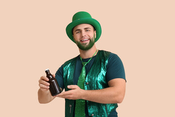 Wall Mural - Young man in leprechaun hat with green beard holding bottle of beer on beige background. St. Patrick's Day celebration