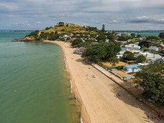 Poster - Aerial view of a sunny Cheltenham Beach day. People relax and enjoy the beach, with homes lining the shore. Coastal community scene.  Devonport, Auckland, New Zealand