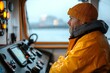 © Maria - a bearded fisherman in a yellow raincoat and beanie focused on navigation inside the fishing trawler cabin