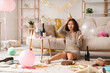 © Pixel-Shot - Young Asian woman with hangover sitting on floor after Birthday party at home