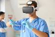 © Pixel-Shot - Male doctor with medical scissors using VR glasses in clinic