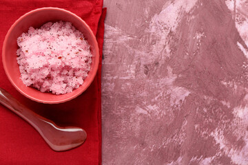 Wall Mural - Bowl of natural body scrub, spatula and napkin on color grunge background