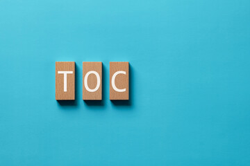 Poster - There is wood block with the word TOC. It is an abbreviation for Theory Of Constraints as eye-catching image.