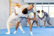 © JackF - Man practices hip flip technique with his sparring partner during group self-defense class