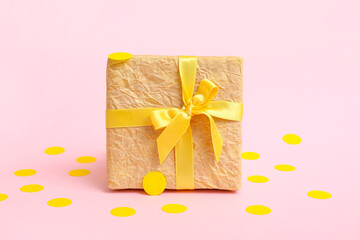 Wall Mural - Gift box and yellow confetti on pink background