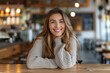 © Baba Images - Portrait of a smiling young Caucasian woman in a coffee shop
