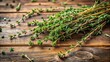 © Buakung - Freshly picked dried thyme sprigs scattered on a rustic wooden table, herbs, foliage,  herbs