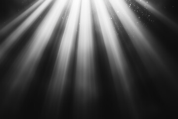Poster - black and white photo of a light shining on a dark background. The light is coming from the top left corner and is shining down on the dark background