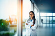 © Aqsapics - Young and successful indian female doctor standing confidently