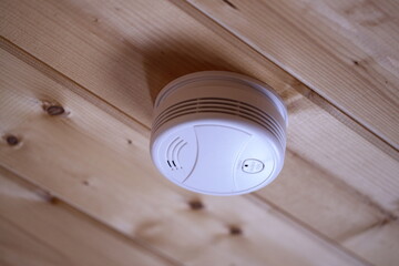 Poster - A smoke detector installed on the ceiling of a house, providing early warning in case of fire.