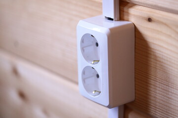 Poster - A close-up shot of an electrical outlet on a wooden wall, useful for decorative or functional purposes.