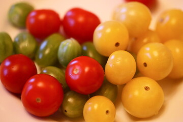 Poster - A variety of colorful tomatoes arranged on a clean white plate.