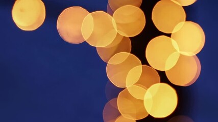 Poster - Soft golden bokeh lights glimmering against deep blue twilight, creating enchanting visual texture with dreamy, magical atmosphere of festive nighttime elegance