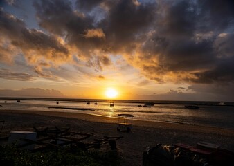 Wall Mural - sunset over tranquil beach with silhouetted boats.