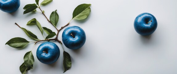 Poster - blue apples with leaves arranged on a white background with additional apple on side copy space