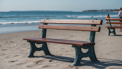 Canvas Print - Wooden park bench on sandy beach with ocean waves in background and clear blue sky perfect for coastal leisure scenes Copy Space