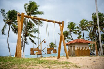 Wall Mural - Tropical beach swings with swaying palms.