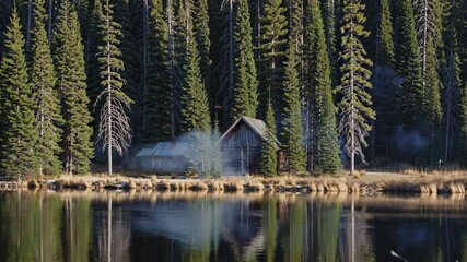 Aufkleber - Cozy cabin by serene lake surrounded by towering pine trees in the heart of nature during autumn