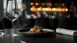 © CYBERPINK - Plate of food on a table in a restaurant. the plate is black and has a small portion of meat on it. the meat appears to be cooked and is garnished with a sprig of green herbs.