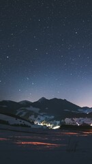 Wall Mural - vertical video of stars moving over winter mountains countryside in starry night sky time lapse