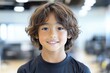 © ChaoticMind - Young boy smiling proudly in a fitness center, showcasing healthy lifestyle and confidence during exercise sessions