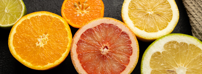 Wall Mural - A close up of several oranges and grapefruits. The oranges are orange and the grapefruits are red