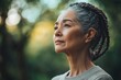 © ChaoticMind - Woman with braided hair gazes thoughtfully into the distance in a serene outdoor setting during golden hour