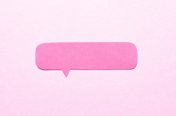 Poster - Cut out blank paper speech bubble of rectangular shape and rounded corners with copy space for text on pink background, flat lay top view conceptual backdrop