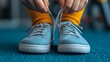 © Dmitry - Securing bright shoelaces on trendy blue sneakers in a cozy setting