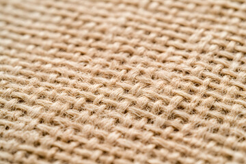 Poster - Close-up of tightly woven natural fiber fabric creating a warm, textured surface. Focus on the intricate pattern of interlocking strands. Warm, inviting material.