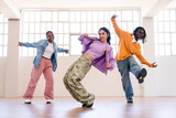 Multiethnic group of young hip hop dancers wearing colorful streetwear dancing outdoors - Stylish multiracial rap crew members meeting and having fun together