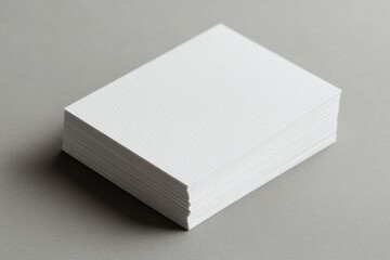 Aufkleber - Stacked blank business cards resting on a minimalist gray surface in natural light for creative design ideas