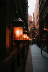 Wall Mural - Lit lamps adorn a city street at dusk, enhancing mood for travel and urban themes